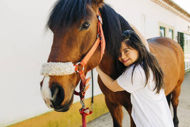 Teenager mit Down-Syndrom kümmert sich um das Pferd und bereitet es zum Reiten vor - DCRF00130