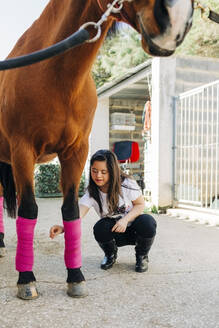 Teenager mit Down-Syndrom kümmert sich um das Pferd und bereitet es zum Reiten vor - DCRF00133