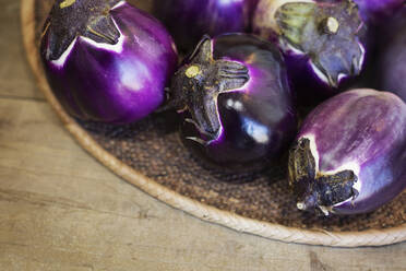 High angle close up of a selection of fresh purple aubergines in a farm shop. - MINF14183