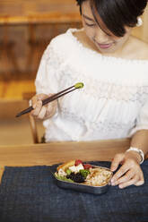 Japanische Frauen essen mit Stäbchen in einem vegetarischen Café. - MINF14210