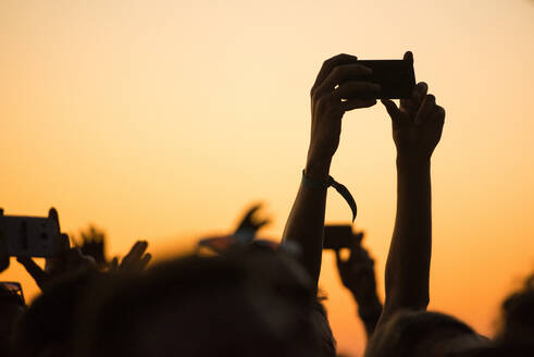 Abgeschnittene Hände beim Fotografieren mit dem Smartphone während eines Musikfestivals - EYF00020