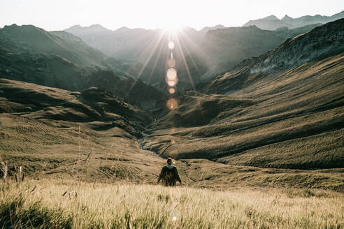 Rear View Of Man Standing By Gras gegen Berge - EYF00033