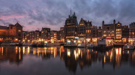 Fluss durch beleuchtete Stadt gegen Himmel in der Abenddämmerung - EYF00091