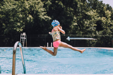 Side View Of Girl Diving Into Swimming Pool - EYF00254