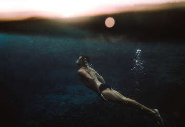 Seitenansicht des Mannes Schwimmen im Meer - EYF00338