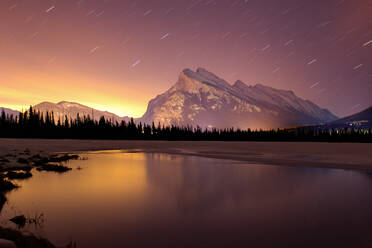 Scenic View Of Lake And Mountains Against Star Trail At Night - EYF00400