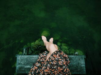 Low Section Of Woman Relaxing On Pier At Lake - EYF00419