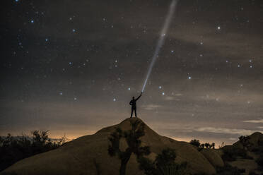 Mann hält Taschenlampe bei Nacht - EYF00468