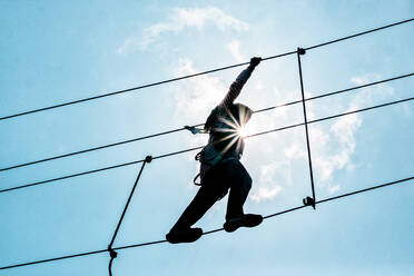 Low Angle View Of Woman Walking On Tightrope Against Sky - EYF00503