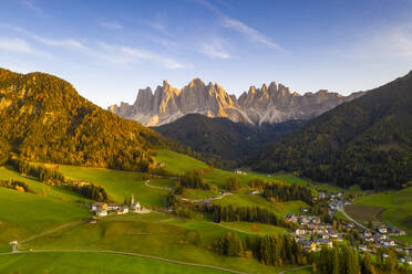 Sonnenuntergang über dem kleinen Dorf Santa Magdalena und Geislerspitzen im Herbst, Luftaufnahme, Funes, Dolomiten, Südtirol, Italien, Europa - RHPLF14017