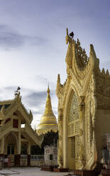 Maha-Wizaya-Pagode in der Abenddämmerung, mit dem goldglänzenden Chedi (Stupa) der Shwedagon-Pagode im mittleren Hintergrund, Yangon (Rangun), Myanmar (Burma), Asien - RHPLF14064