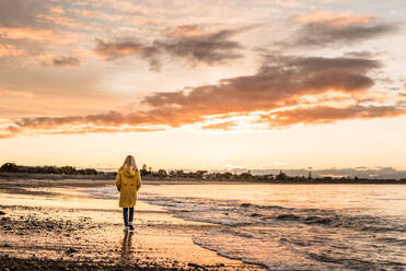 Preteen Mädchen zu Fuß in der Abenddämmerung an einem Strand im Winter - CAVF77123