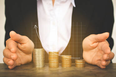Digital Composite Image Of Businessman Covering Stacked Coins With Line Graph - EYF00689