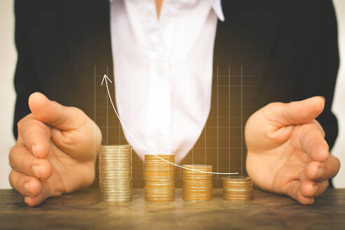 Digital Composite Image of Businessman Abdeckung gestapelten Münzen mit Line Graph - EYF00689