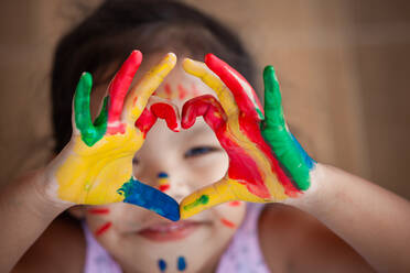 Close-Up Portrait Of Cute Girl With Colorful Hands Making Heart Shape - EYF00733