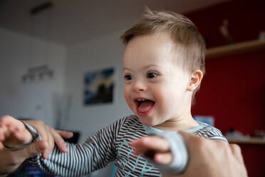 Happy Boy With Down Syndrome Held By Father At Home - EYF00806