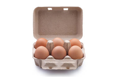 Nahaufnahme von braunen Eiern im Karton auf weißem Hintergrund - EYF00905