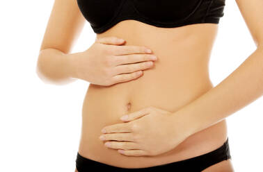 Midsection Of Woman Touching Abdomen Against White Background - EYF00949