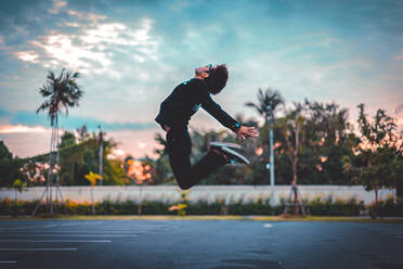 Man Jumping Over Road Against Sky During Sunset - EYF01005