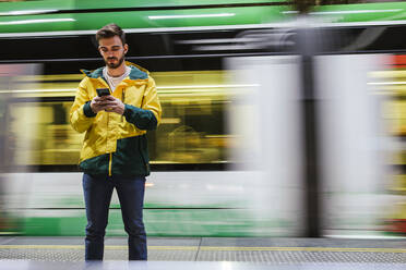 Mann benutzt Mobiltelefon in der U-Bahn-Station - LJF01408