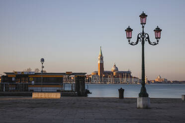 Italien, Venedig, Straßenlaterne an der Küste mit San Giorgio Maggiore im Hintergrund - MRAF00488