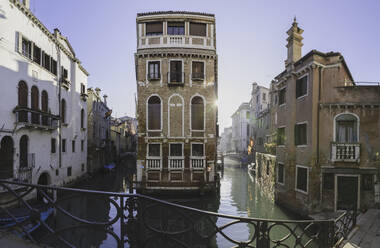 Italien, Venedig, Sonne beleuchtet Häuser entlang des venezianischen Kanals - MRAF00500