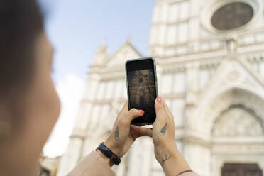 Frau macht Smartphone-Foto von der Kirche Santa Croce, Florenz, Italien - FMOF00905