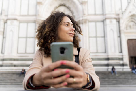 Frau mit Smartphone in der Kirche Santa Croce, Florenz, Italien, lizenzfreies Stockfoto