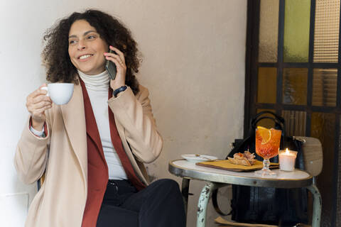 Lächelnde Frau am Telefon in einem Cafe, lizenzfreies Stockfoto