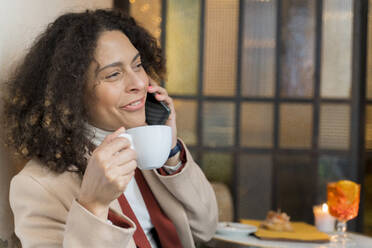 Lächelnde Frau am Telefon in einem Cafe - FMOF00928