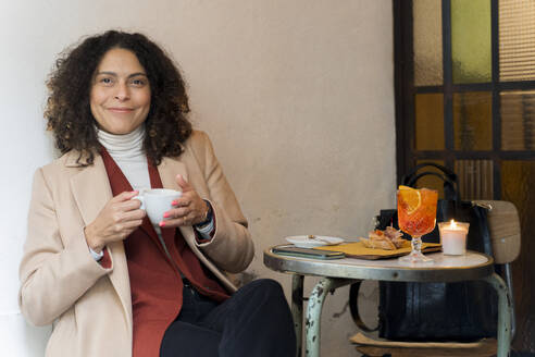 Porträt einer lächelnden Frau in einem Kaffeehaus - FMOF00929