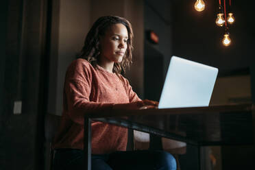 Junge Frau mit Laptop in einem Café - JPIF00484