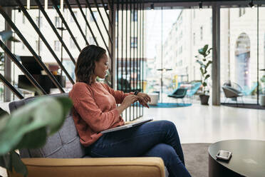 Young woman checking the time in a foyer - JPIF00493