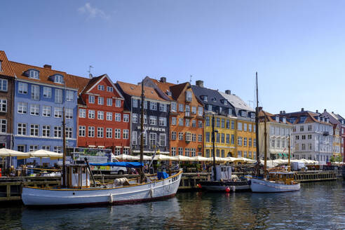 Dänemark, Kopenhagen, Boote vertäut entlang Nyhavn Kanal mit bunten Stadthäusern im Hintergrund - LBF02939