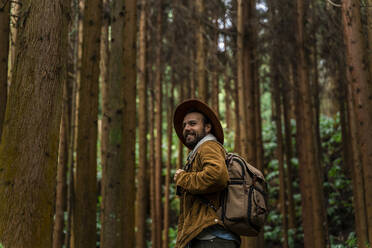 Lächelnder Mann in einem von Bäumen umgebenen Wald, Insel Sao Miguel, Azoren, Portugal - AFVF05684