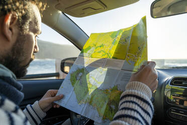 Mann schaut im Auto auf die Karte, Insel Sao Miguel, Azoren, Portugal - AFVF05695