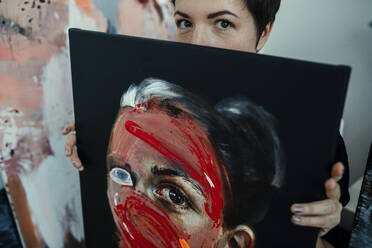 Porträt einer Malerin mit Gemälde in ihrem Atelier - OGF00239