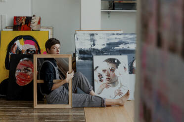 Eine Malerin sitzt in ihrem Atelier auf dem Boden - OGF00252