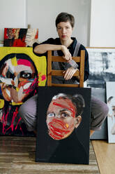 Porträt einer auf einem Stuhl sitzenden Malerin in ihrem Atelier - OGF00255