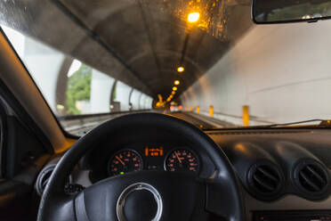 Italien, Lombardei, Lecco, Innenraum eines Autos, das durch einen Tunnel fährt - TCF06265