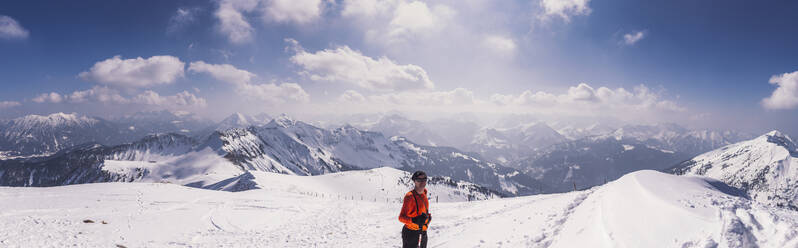 Glücklicher männlicher Wanderer auf einem schneebedeckten Berg im Skiurlaub in Achenkirch, Tirol, Österreich - DHEF00151