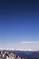 Idyllischer Blick auf eine schneebedeckte Bergkette vor blauem Himmel am Nassfeld, Österreich - DHEF00153