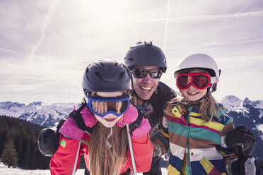 Happy father embracing daughters while enjoying ski holiday at Spitzingsee, Bavaria, Germany - DHEF00156