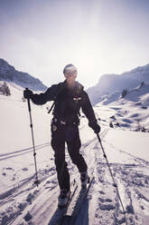 Happy hiker skiing on snow covered mountain at Achenkirch, Tyrol, Austria during sunny day - DHEF00162