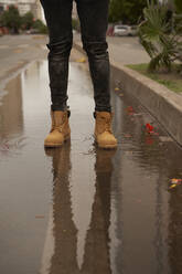Legs of young man standing in a puddle - VEGF01747