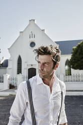 Portrait of man in old-fashioned clothes at a church in the countryside - RORF02033