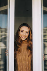 Portrait of happy young woman at the window - DCRF00158