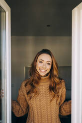 Portrait of happy young woman at the window - DCRF00159