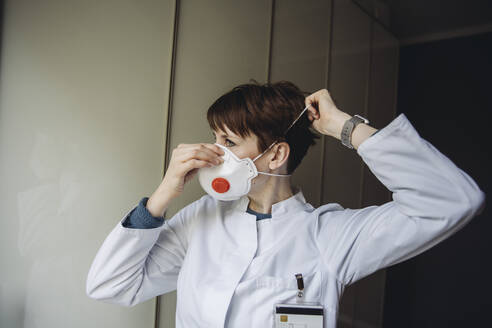 Female doctor putting on FFP3 mask - MFF05077