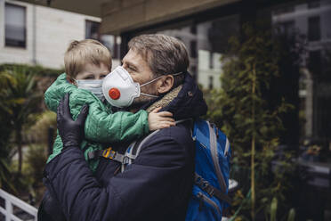 Vater mit Sohn, beide mit Schutzmaske, im Freien - MFF05083